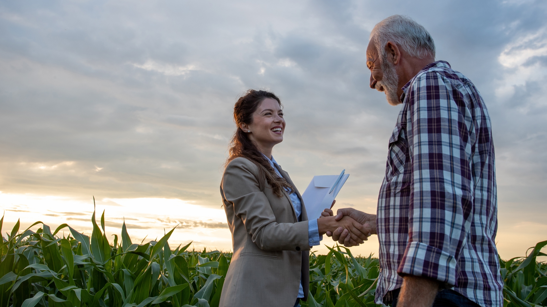 Woman Shaking Hands with Farmer in Fields